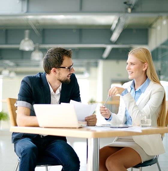Man and woman reviewing documents with an adviser